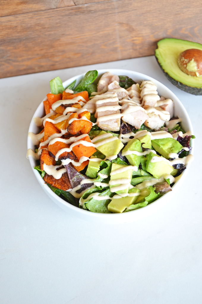 This Paleo Balance Bowl is packed with everything you need to make a perfectly balanced meal in one bowl! Chicken, Butternut Squash & Avocado top greens dressed in a tahini sauce! So tasty and it is paleo & whole 30 approved!