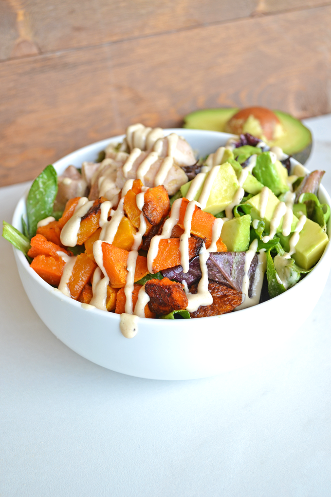 This Paleo Balance Bowl is packed with everything you need to make a perfectly balanced meal in one bowl! Chicken, Butternut Squash & Avocado top greens dressed in a tahini sauce! So tasty and it is paleo & whole 30 approved!