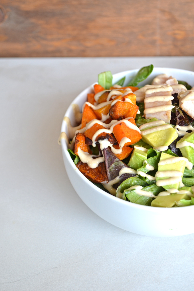 This Paleo Balance Bowl is packed with everything you need to make a perfectly balanced meal in one bowl! Chicken, Butternut Squash & Avocado top greens dressed in a tahini sauce! So tasty and it is paleo & whole 30 approved!