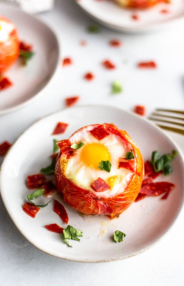 These Pizza Baked Eggs are a super simple breakfast idea. Stuff a tomato with pepperoni and an egg and bake for a gluten and dairy free life hack. 