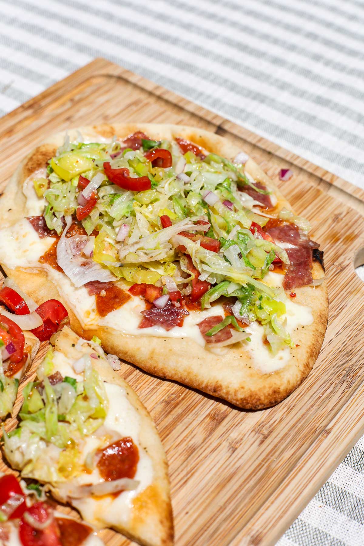 Savor our Italian Grinder Flatbread! Loaded with Italian meats, cheese, and veggies for a perfect, easy-to-make meal.