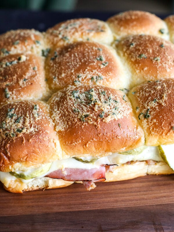 Melted Swiss cheese, savory ham, & slow-cooked pulled pork on sweet Hawaiian rolls. These Cuban sliders are a crowd-pleasing party hit!
