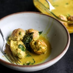 Easy one-pan dinner! Juicy chicken dumpling meatballs baked in a creamy, spinach-packed coconut curry sauce.