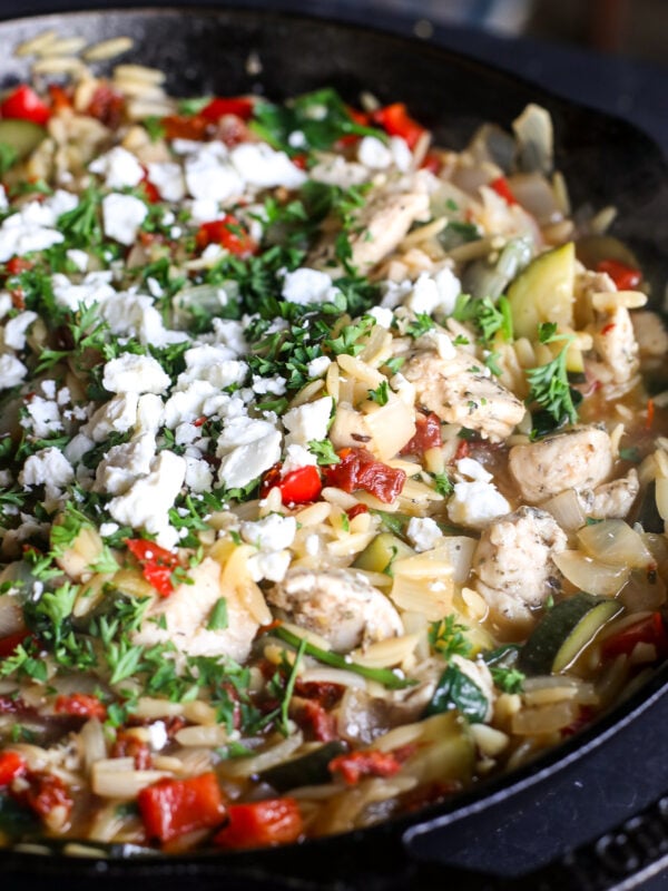 One-pan dinner! This Lemon-Herb Chicken Orzo Skillet is packed with zucchini, spinach, sun-dried tomatoes, and feta.