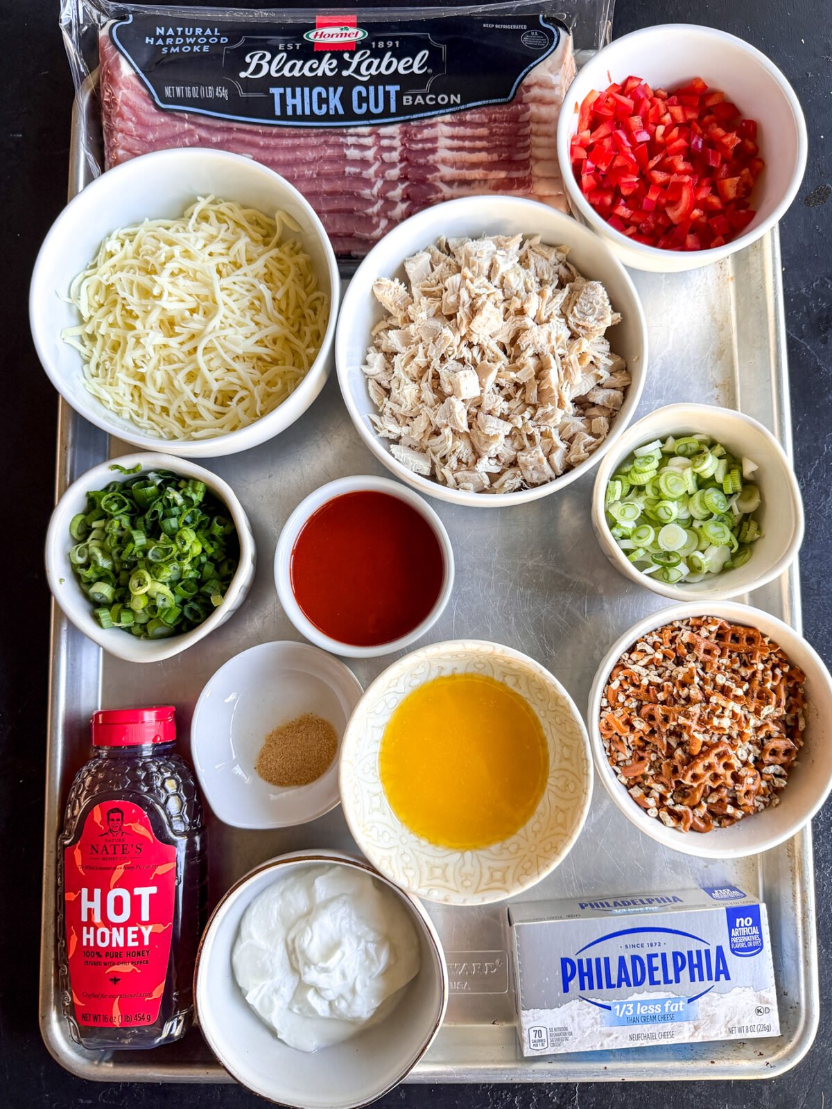 The ultimate party dip! Creamy hot honey chicken and bacon topped with a buttery, crunchy pretzel crust. Bake until gooey.