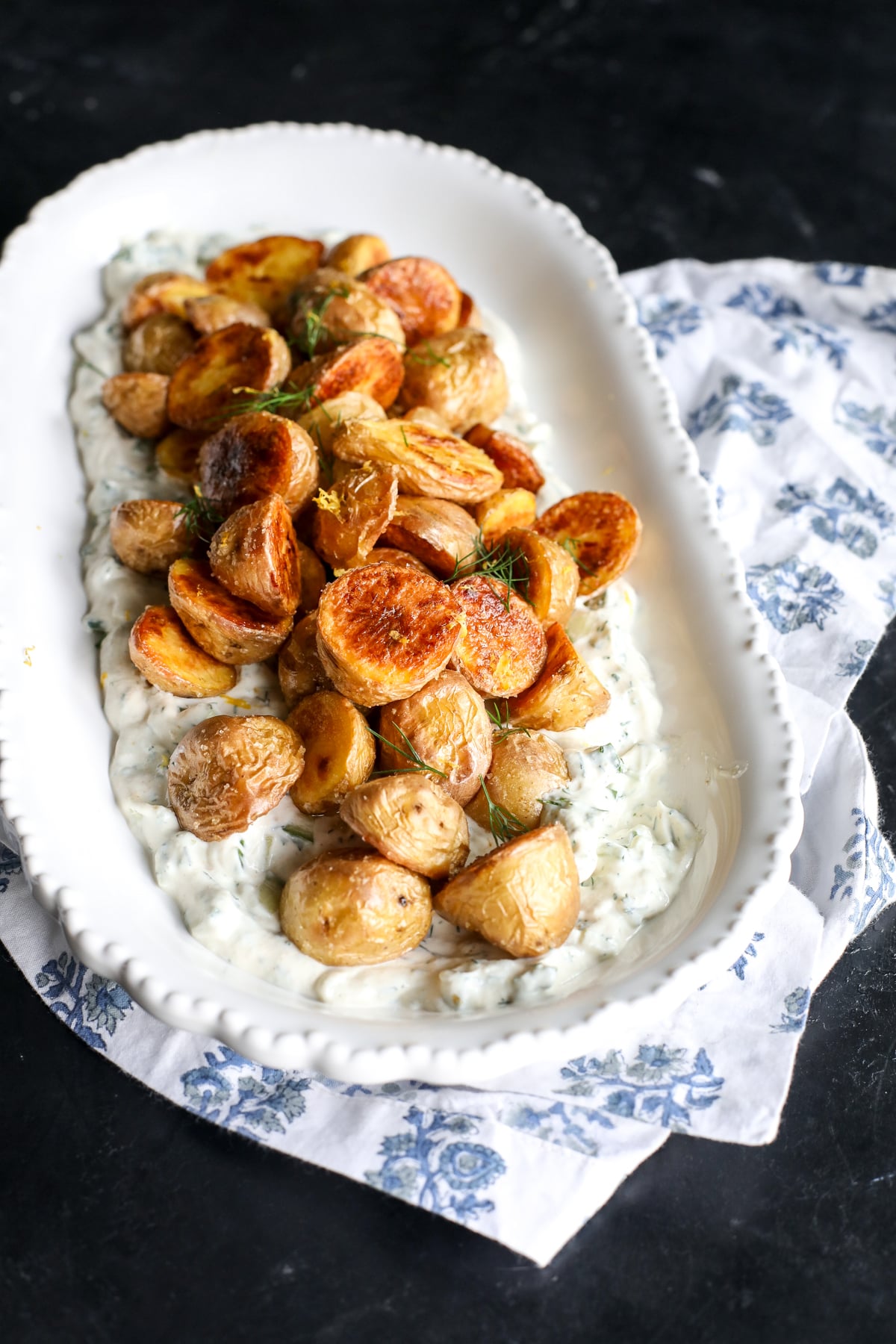 Crispy potatoes meet a creamy cucumber dill sauce. This easy, healthy side features roasted gold potatoes over a refreshing Greek yogurt dressing.