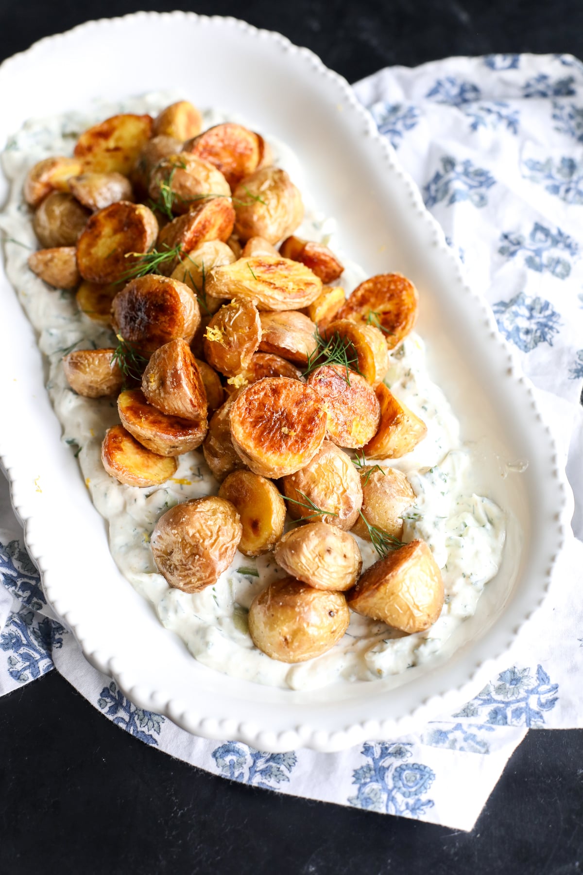 Crispy potatoes meet a creamy cucumber dill sauce. This easy, healthy side features roasted gold potatoes over a refreshing Greek yogurt dressing.