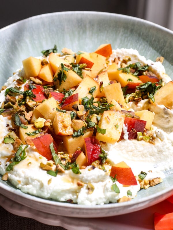 Creamy whipped feta topped with fresh peaches, pistachios, and hot honey makes an easy, crowd-pleasing summer appetizer.