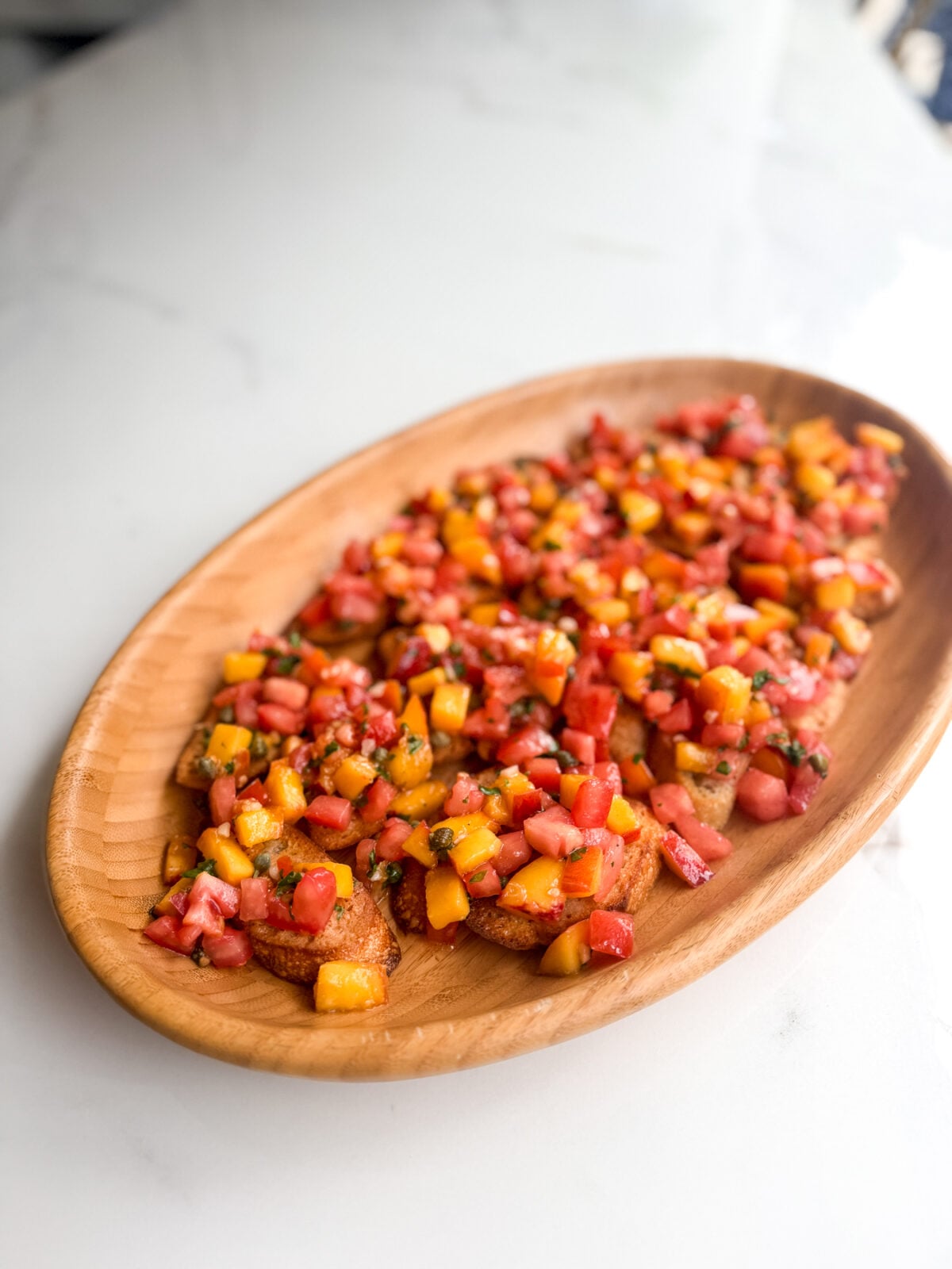 Fresh peach tomato bruschetta with basil and a tangy vinaigrette. An easy make-ahead appetizer for summer gatherings.