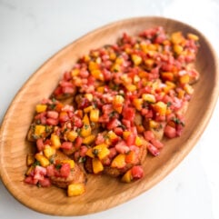 Fresh peach tomato bruschetta with basil and a tangy vinaigrette. An easy make-ahead appetizer for summer gatherings.