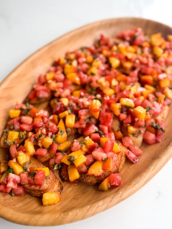 Fresh peach tomato bruschetta with basil and a tangy vinaigrette. An easy make-ahead appetizer for summer gatherings.