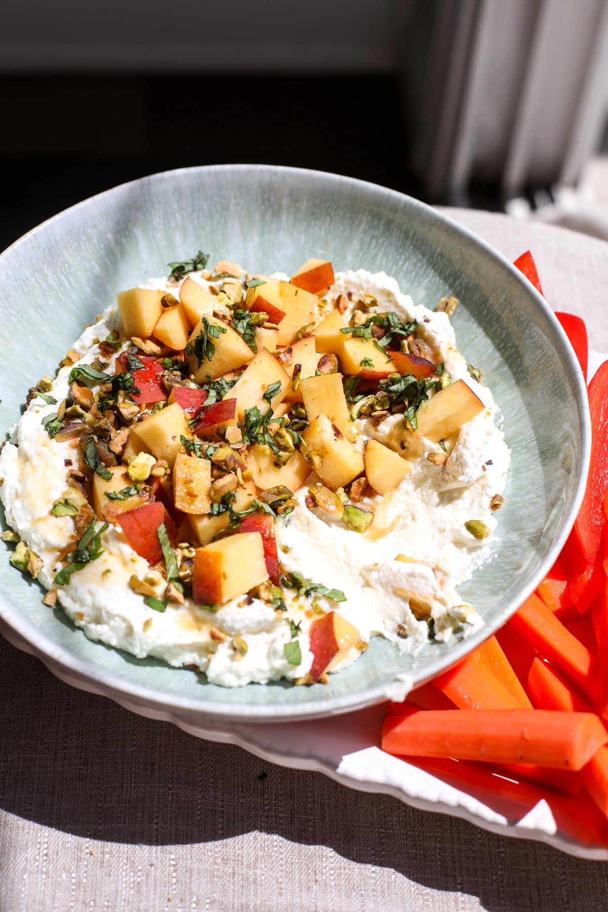Creamy whipped feta topped with fresh peaches, pistachios, and hot honey makes an easy, crowd-pleasing summer appetizer.