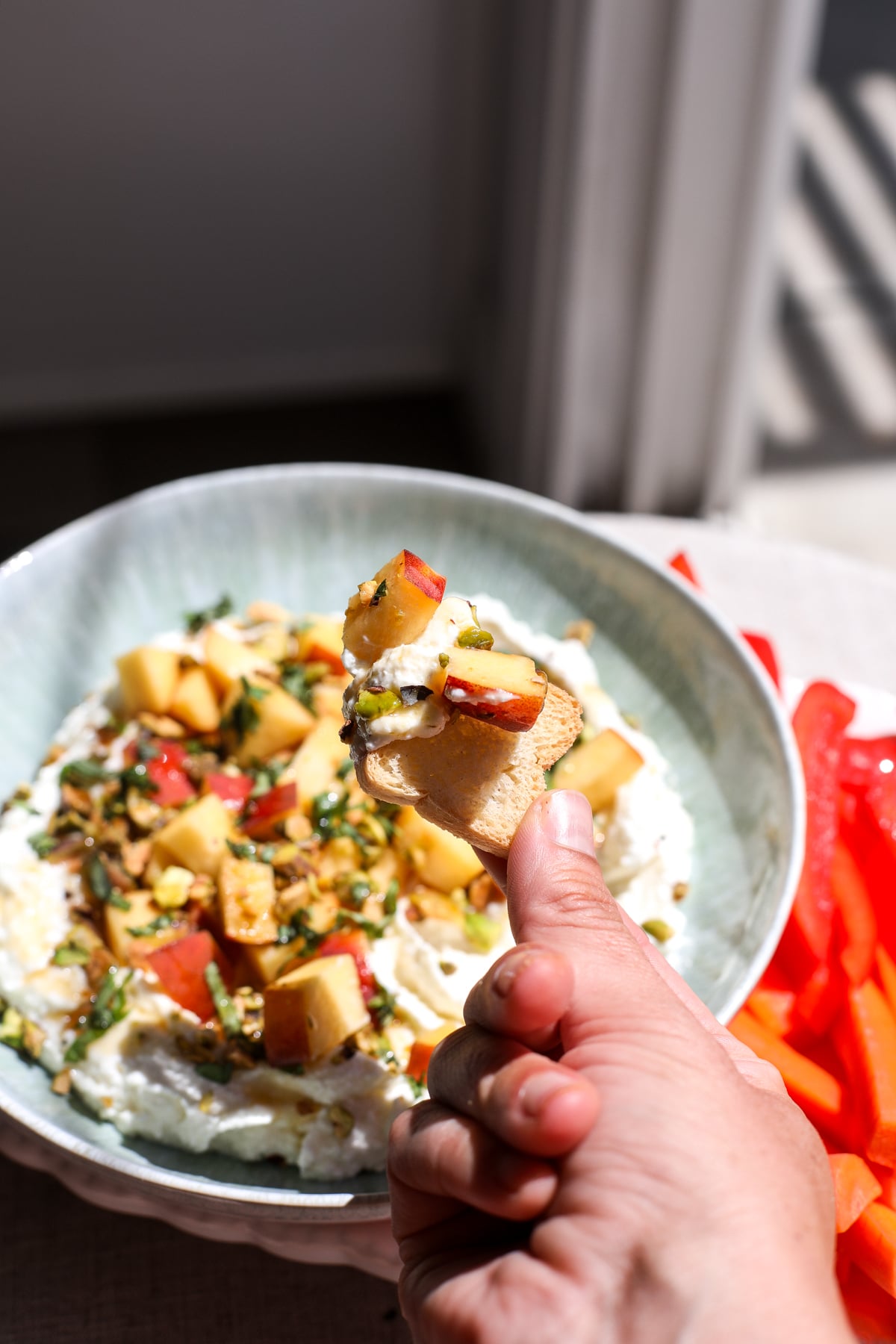 Creamy whipped feta topped with fresh peaches, pistachios, and hot honey makes an easy, crowd-pleasing summer appetizer.