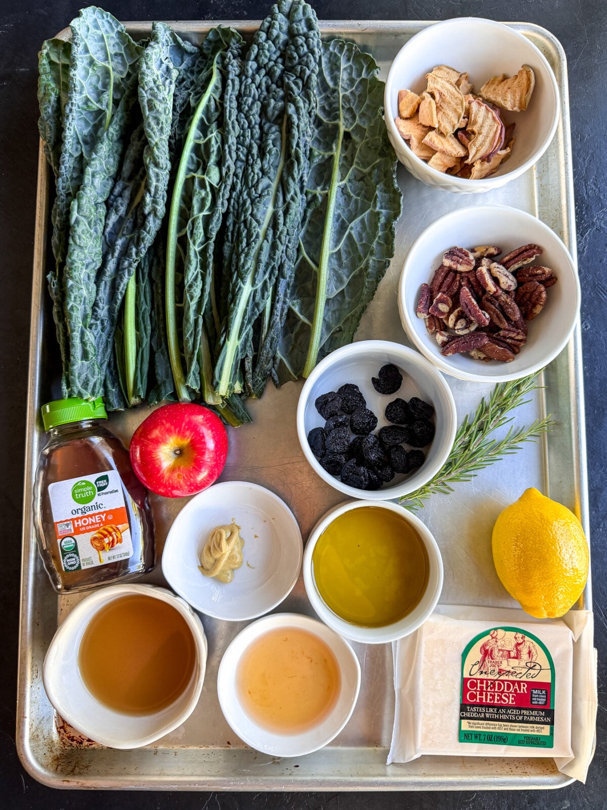 This Apple Kale Salad is loaded with crisp apples, sharp cheddar, pecans, dried cherries and apple chips, tossed in a homemade rosemary apple vinaigrette.