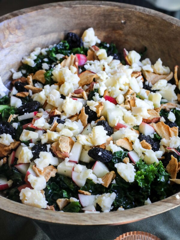 This Apple Kale Salad is loaded with crisp apples, sharp cheddar, pecans, dried cherries and apple chips, tossed in a homemade rosemary apple vinaigrette.