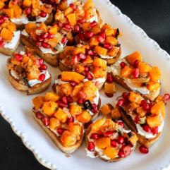 This Butternut Squash & Pomegranate Bruschetta is an easy holiday appetizer with creamy goat cheese, roasted squash and a tangy mustard dressing.